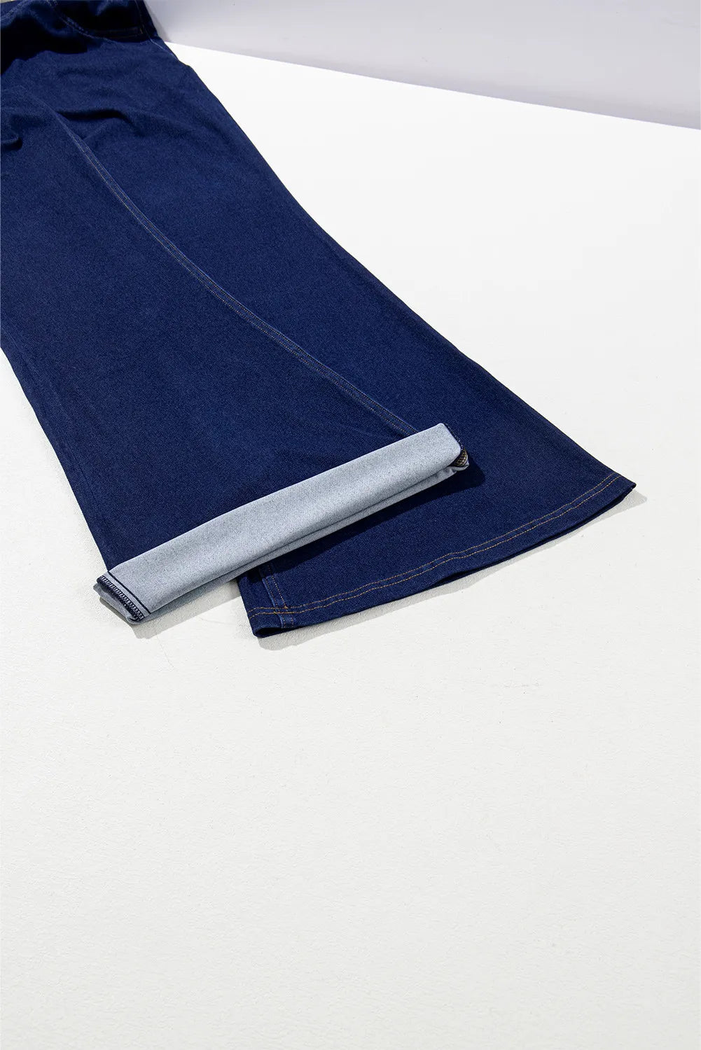 Rolled-up blue denim fabric on a white background