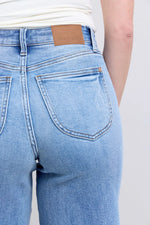 Light blue jeans with a brand label on a plain background