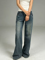 Person wearing blue jeans on a plain background