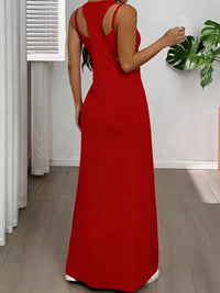 Person wearing a red dress with cut-out back in a room with a plant.