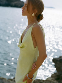 Woman in a yellow dress standing by the water