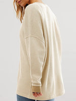 Beige long-sleeve shirt worn by a person on a plain background