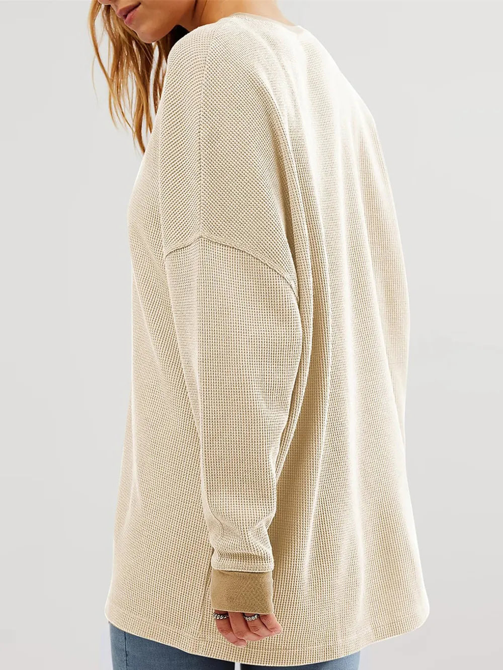 Beige long-sleeve shirt worn by a person on a plain background