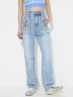 Light blue jeans with floral embroidery on a white background
