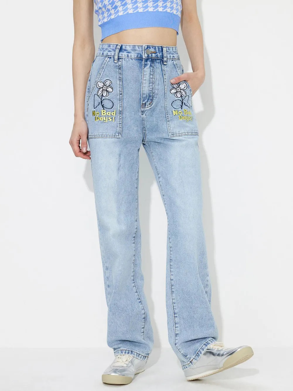Light blue jeans with floral embroidery on a white background