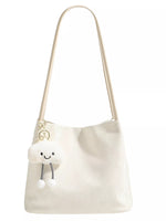 White shoulder bag with a plush toy on a white background
