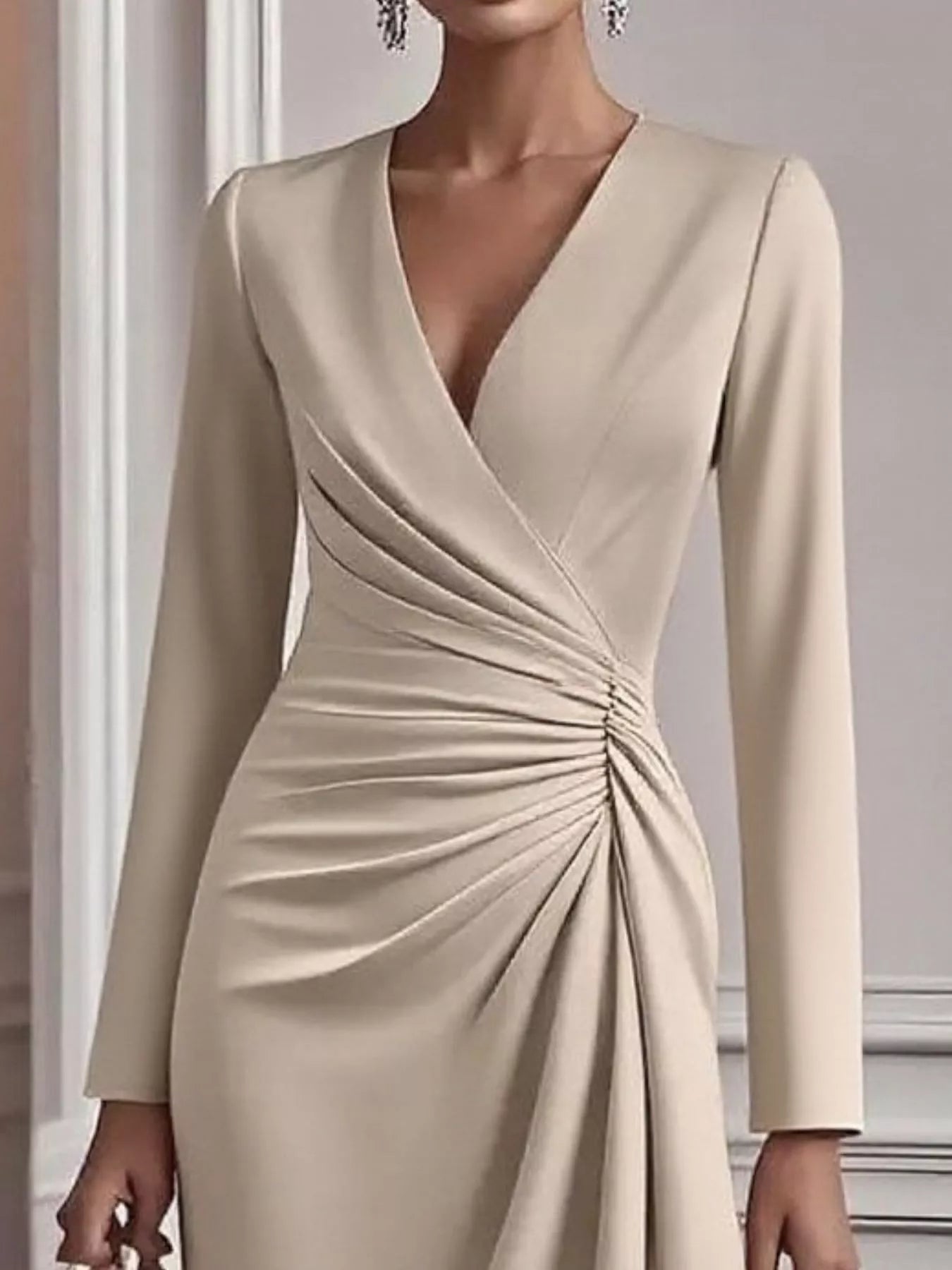 Beige long-sleeve dress with a draped design on a neutral background