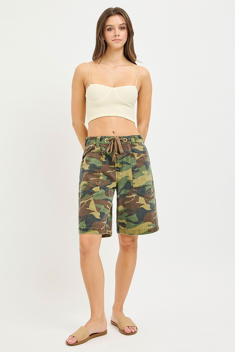 Woman wearing camouflage shorts on a white background