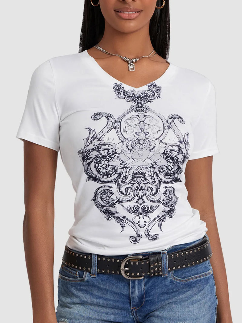 Person wearing a white t-shirt with black intricate design, paired with blue jeans and a black belt.