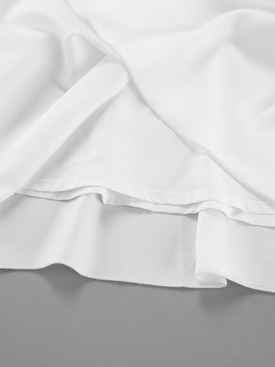 Close-up of white satin fabric with folds on a gray background