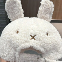 Plush toy with bunny ears and a sad expression on a neutral background