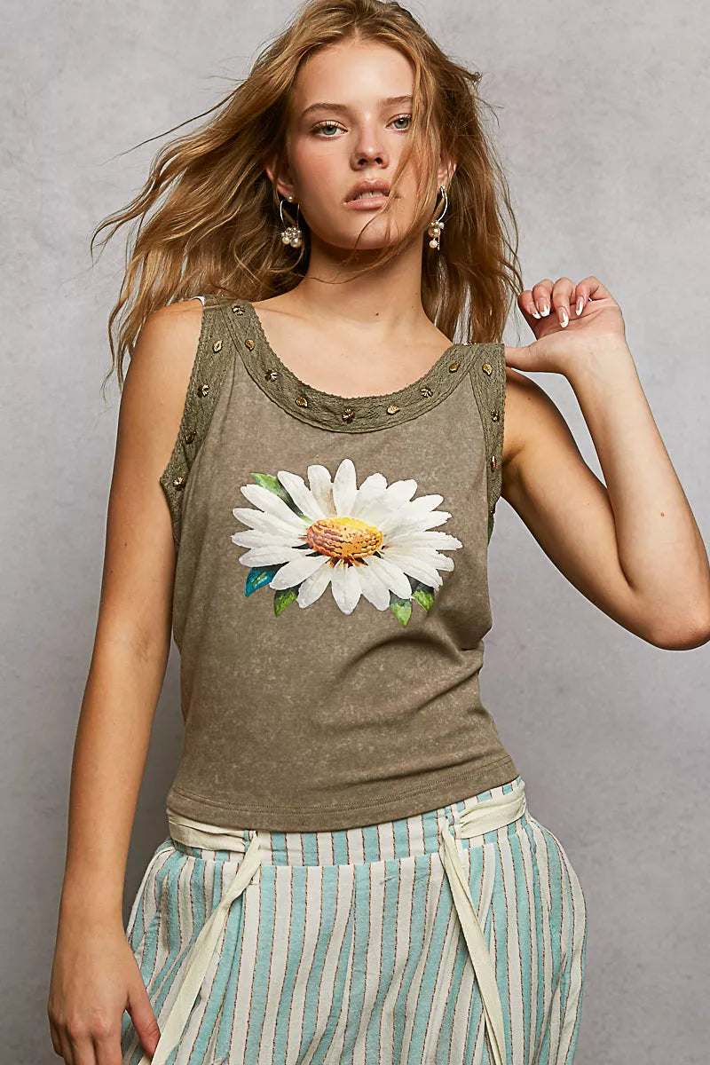 Woman wearing a tank top with a floral design against a gray background