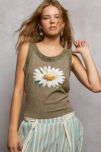 Woman wearing a tank top with a floral design against a gray background