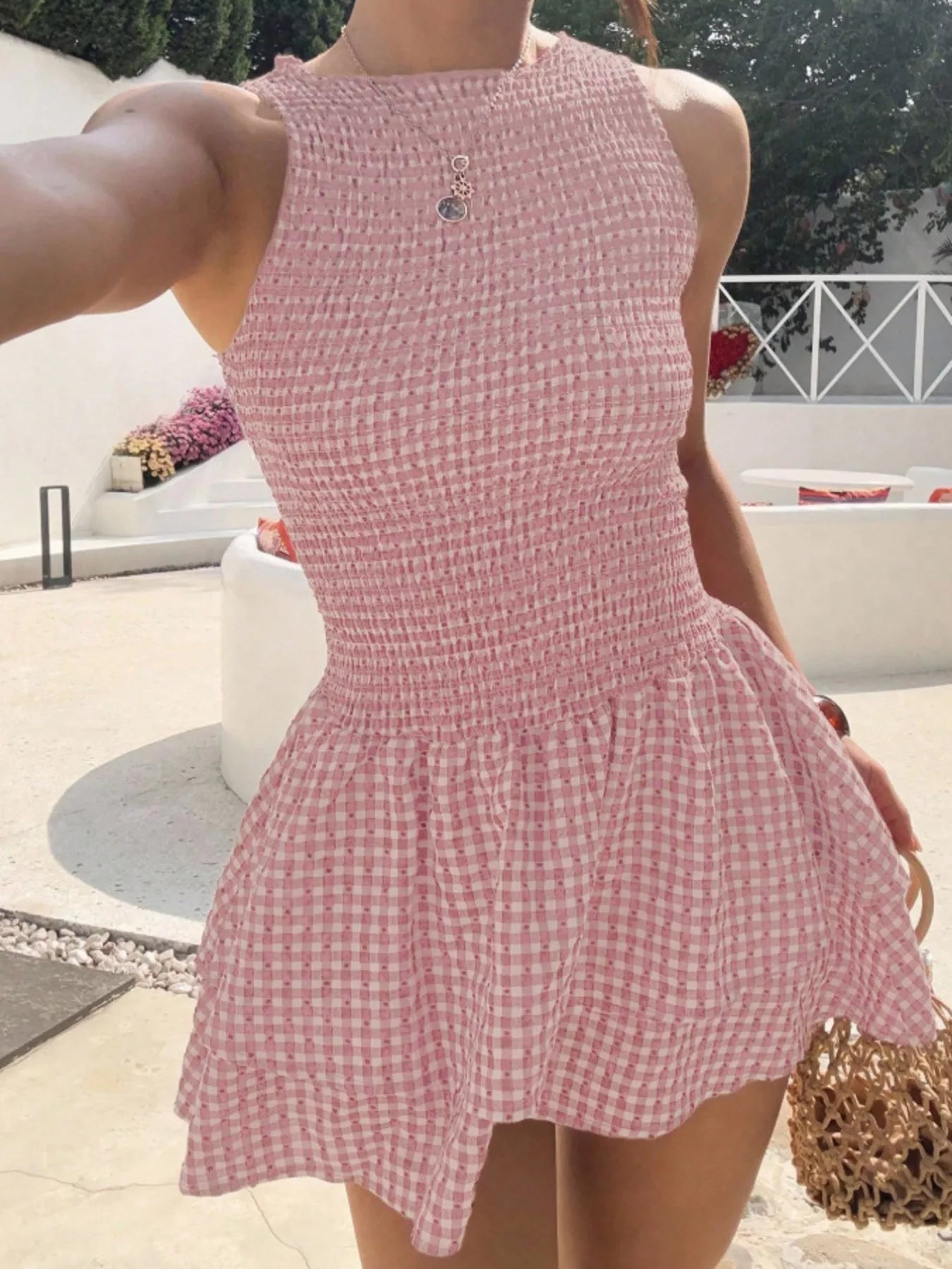 Person wearing a pink checkered dress outdoors.