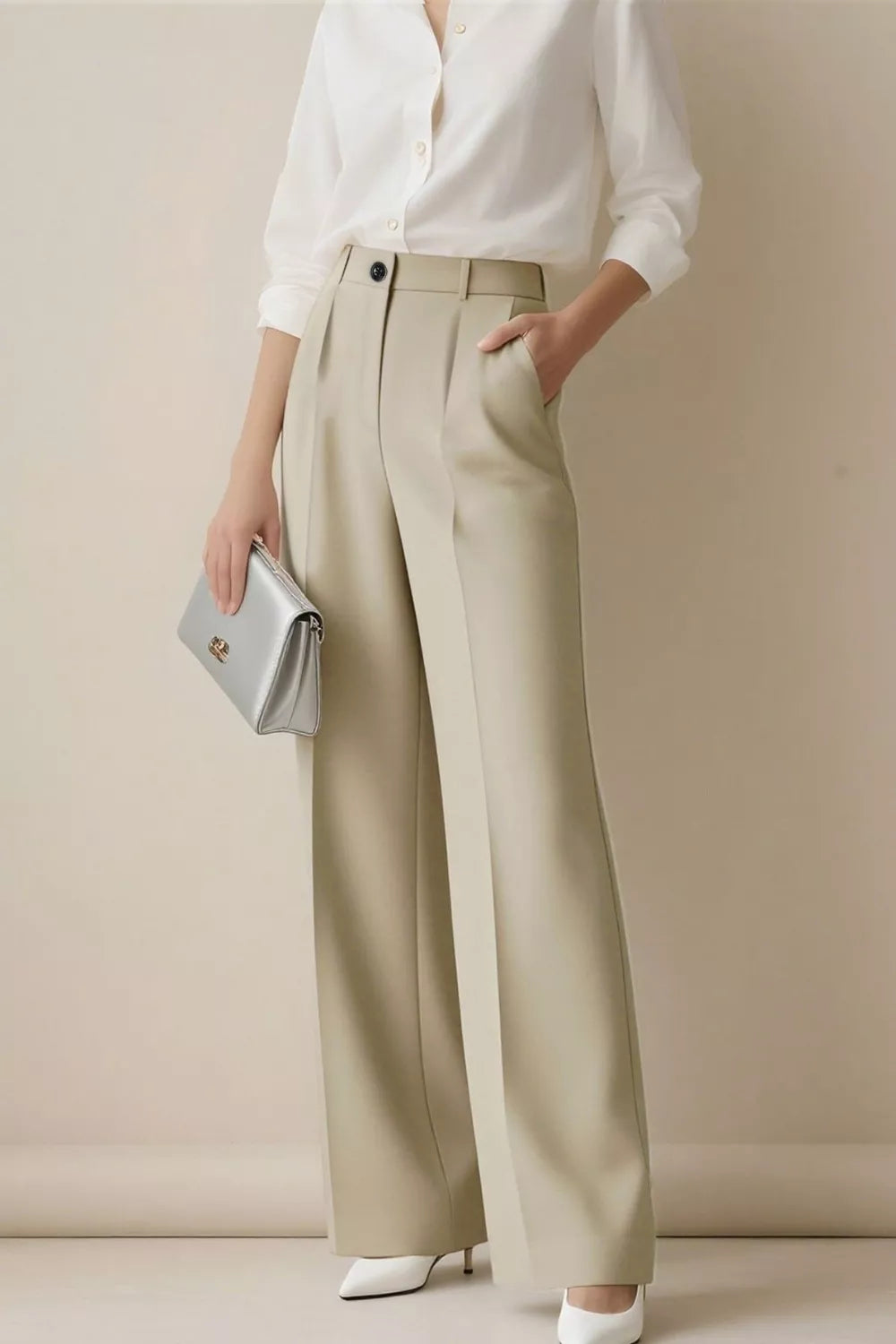 Person wearing a white shirt and beige wide-leg pants against a plain background