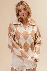 Woman wearing a beige and white diamond patterned sweater against a beige background