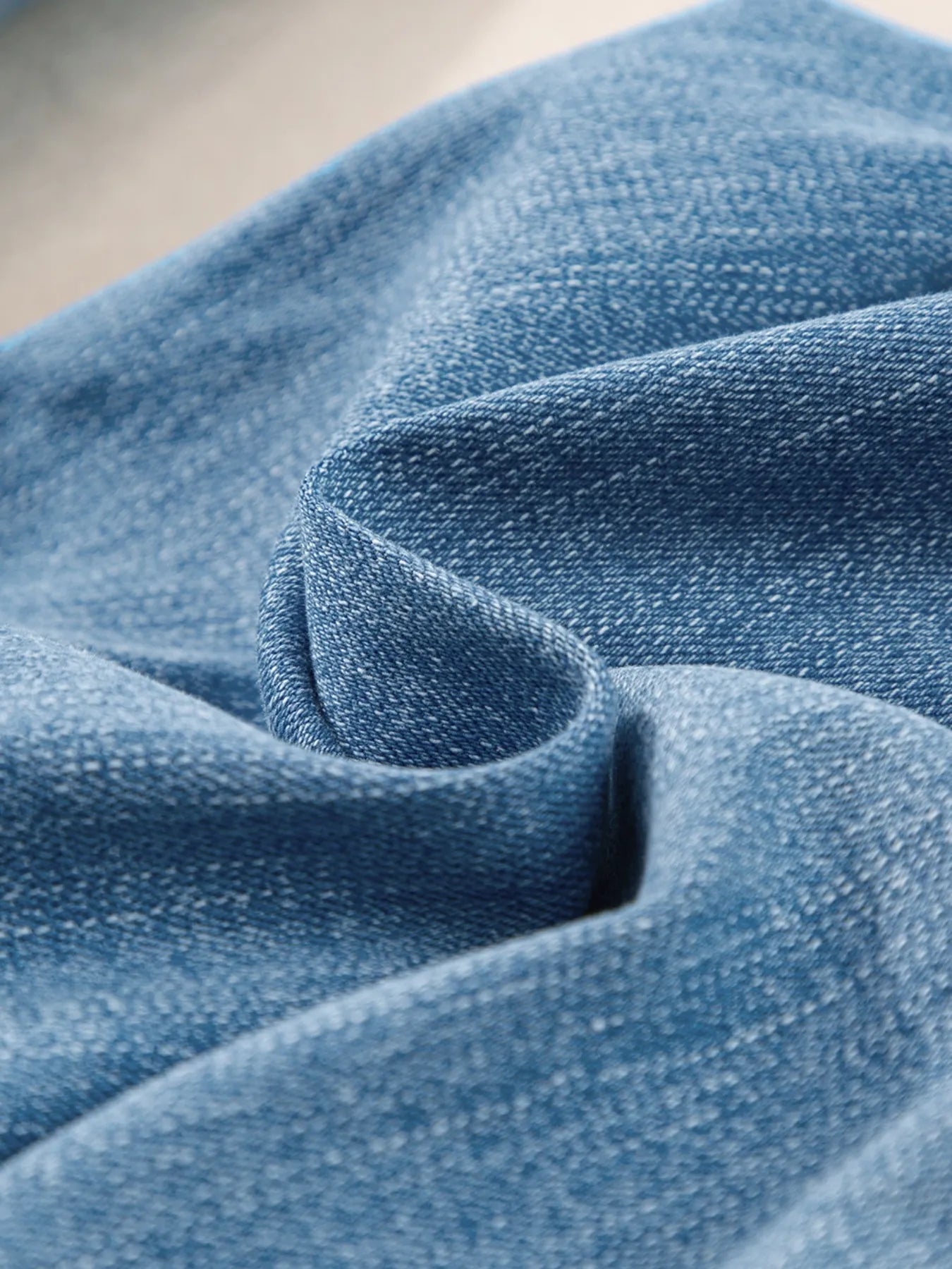 Close-up of blue denim fabric with a soft texture.