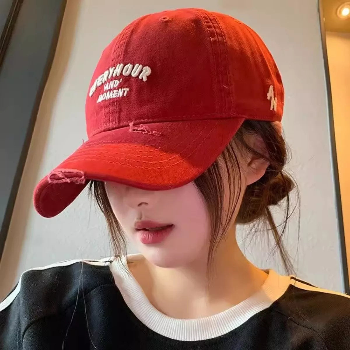 Person wearing a red cap with white text, indoors.