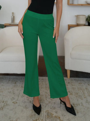 Person wearing green pants and black shoes in a living room setting