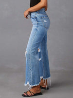 Person wearing blue jeans with a gray background