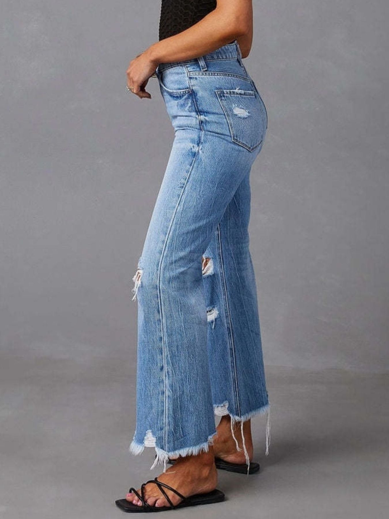 Person wearing blue jeans with a gray background
