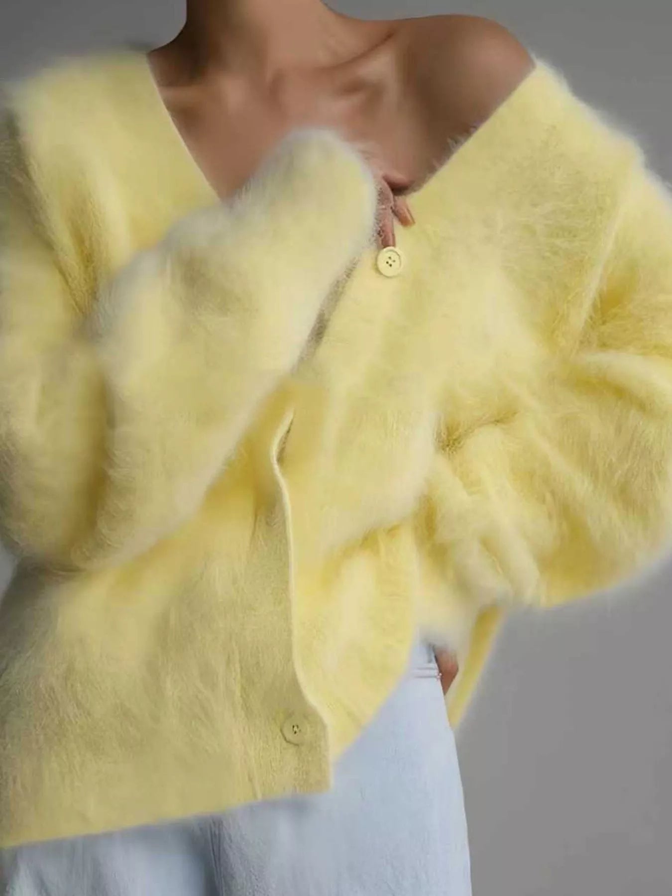Yellow fluffy cardigan worn by a person, with a blurred background