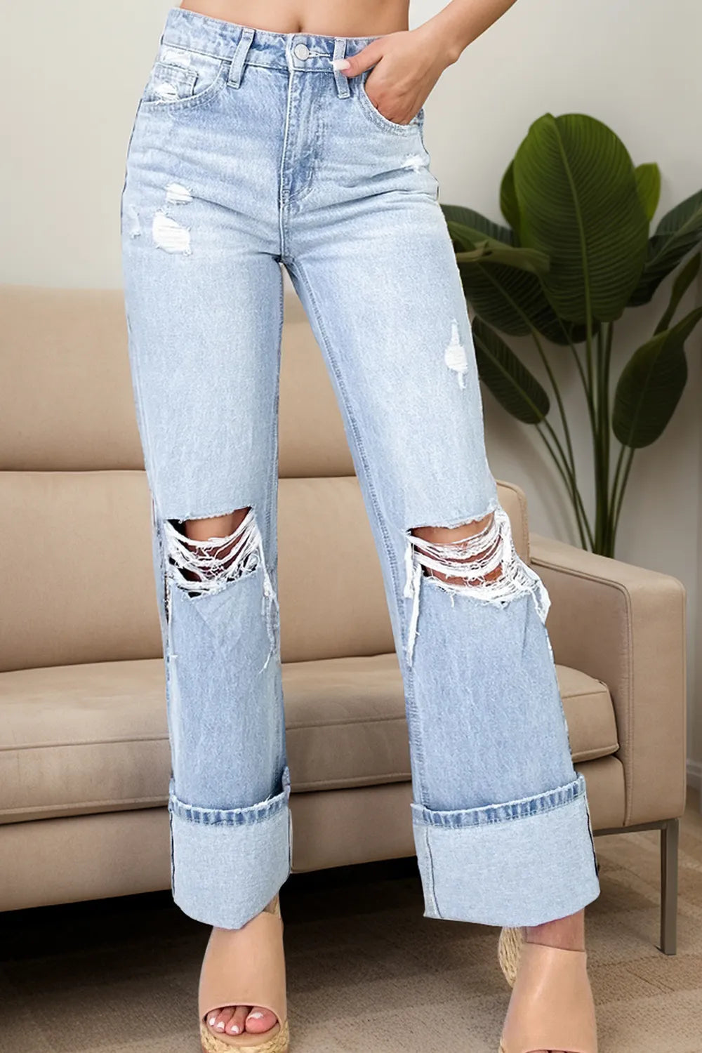 Light blue distressed jeans worn by a person in a living room setting.
