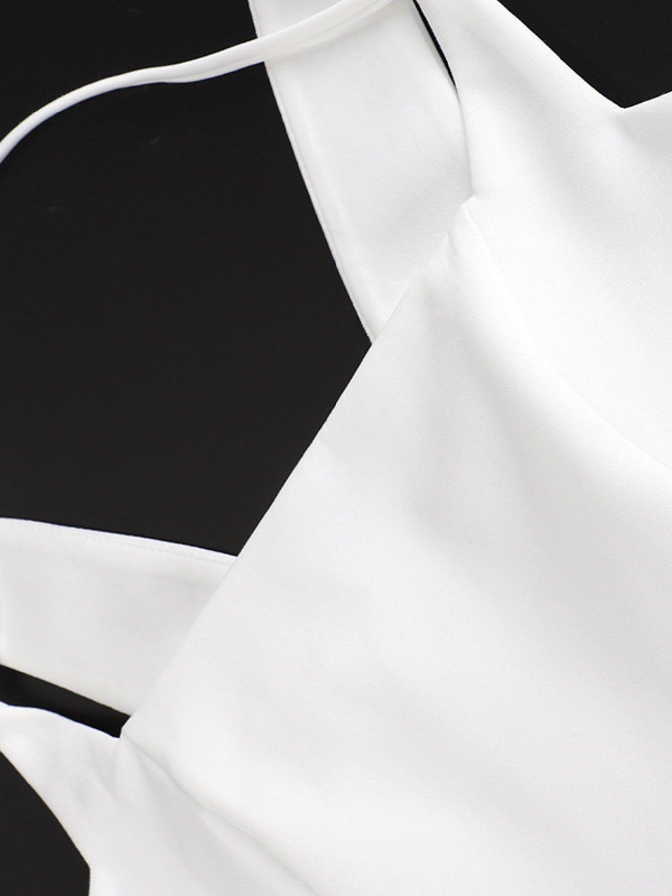 White blouse with thin straps on a black background