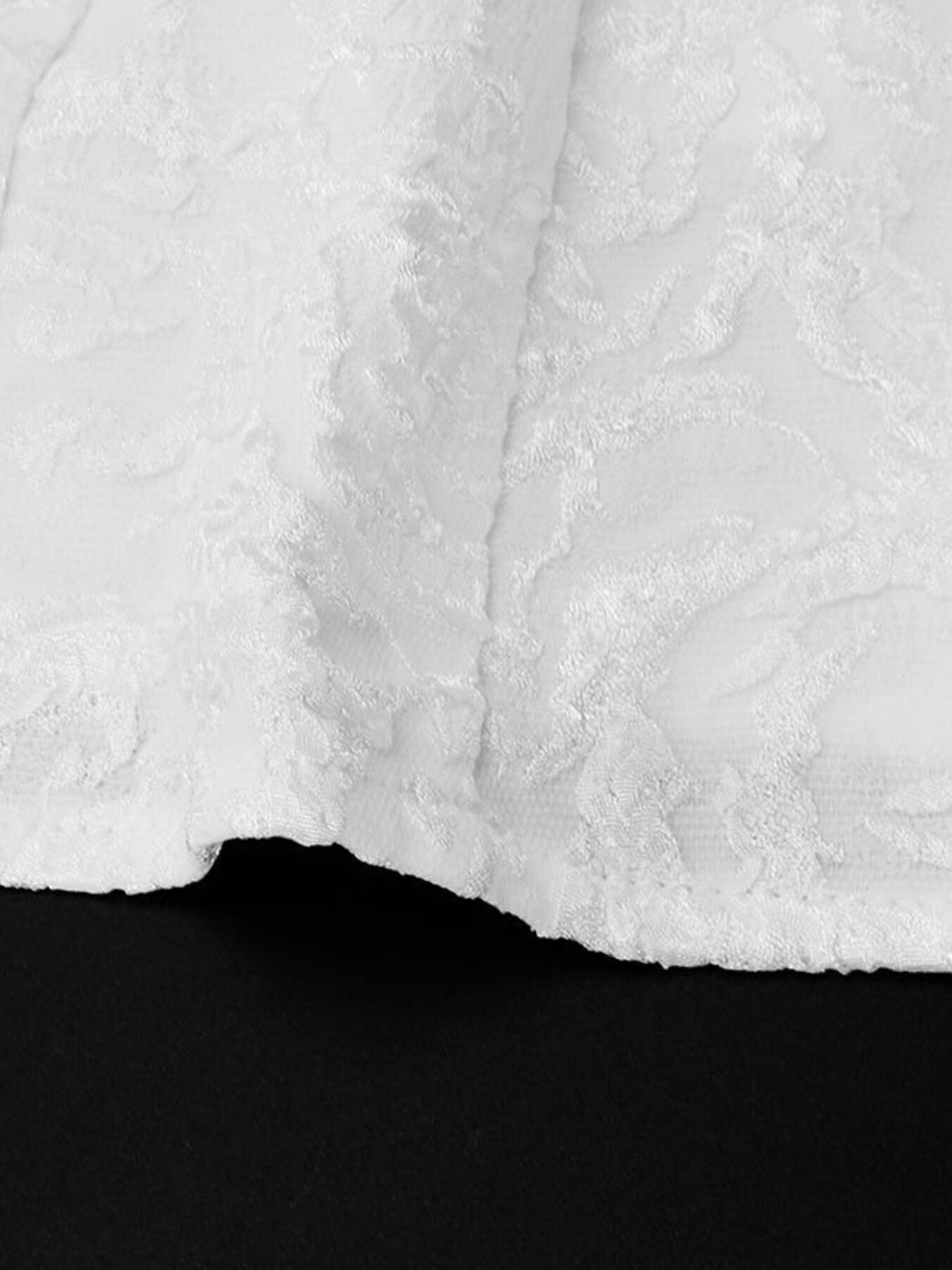 Close-up of textured white fabric with a black background