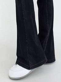 Black jeans worn by a person on a white background