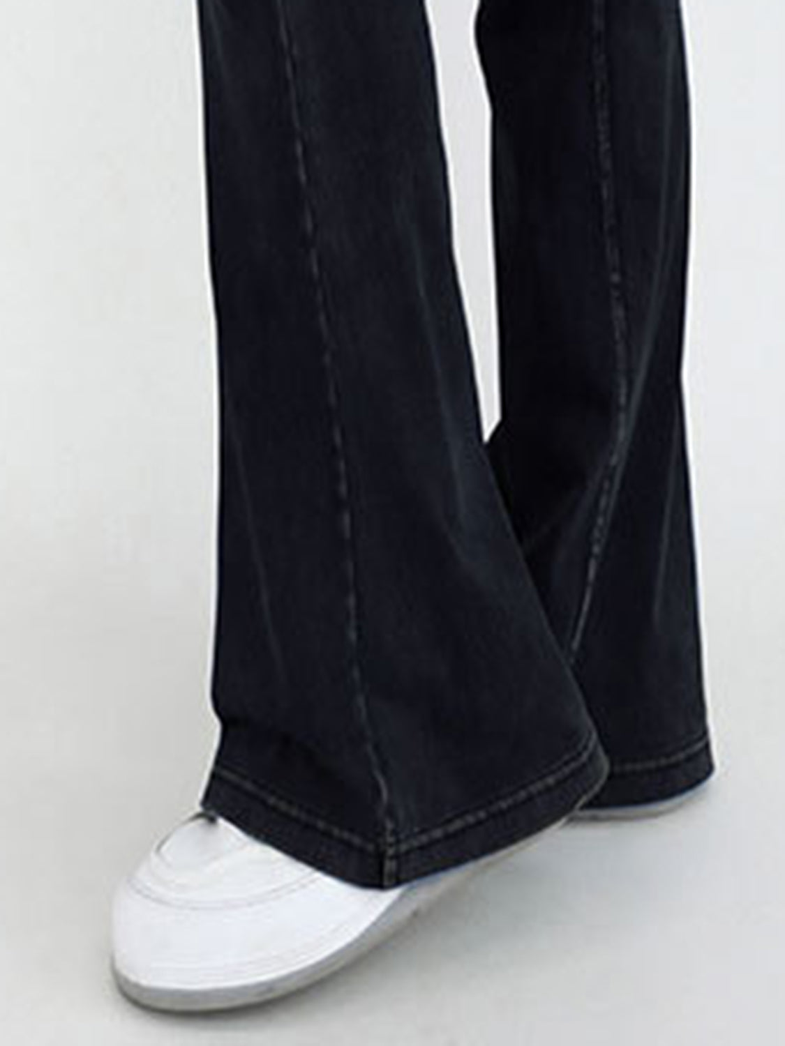 Black jeans worn by a person on a white background