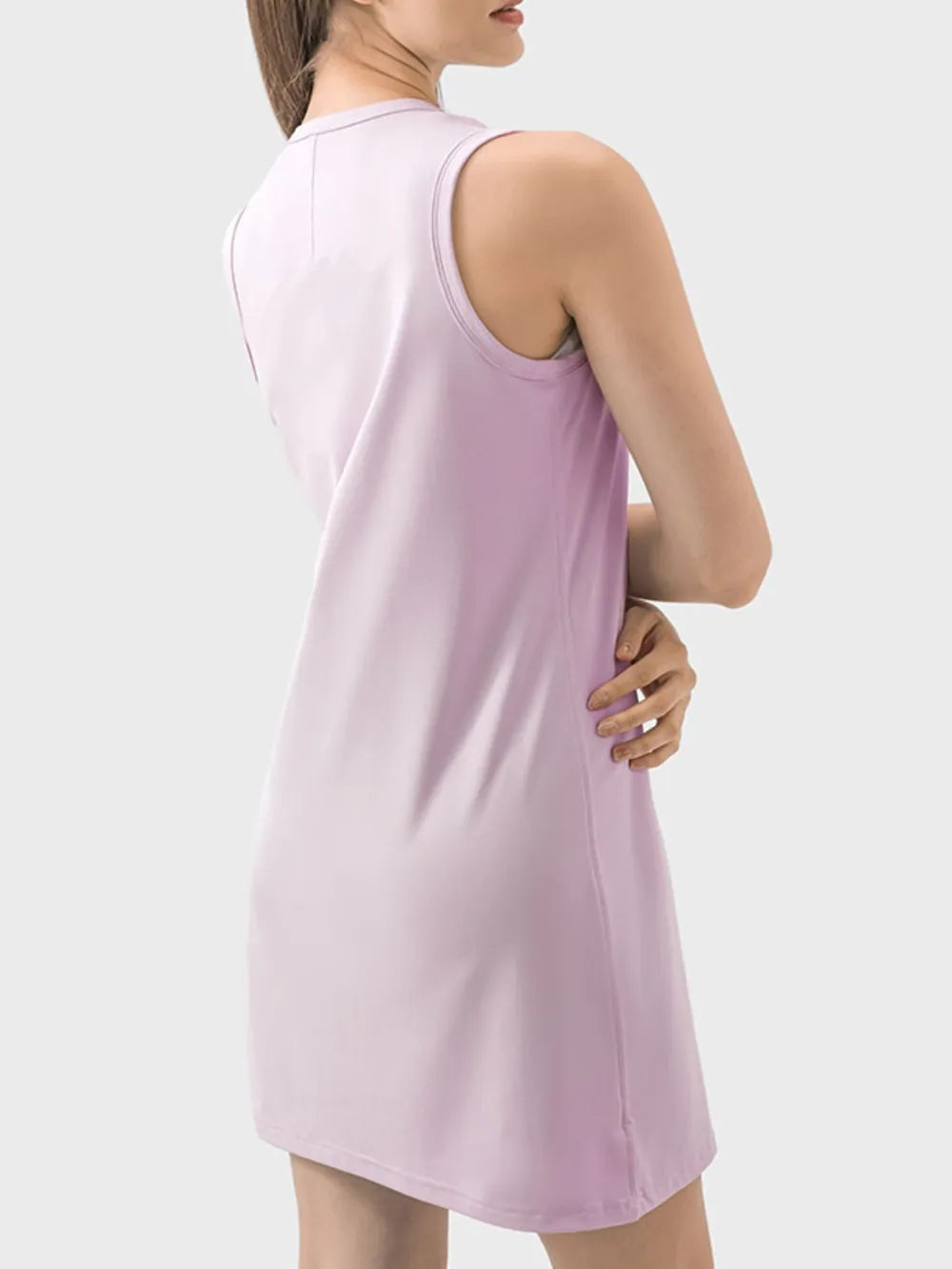 Woman wearing a light purple sleeveless dress against a white background