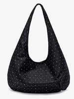 Black shoulder bag with white polka dots on a white background