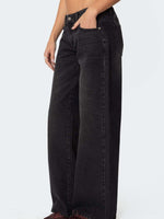 Black wide-leg jeans worn by a person on a white background