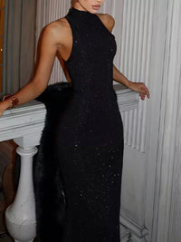 Woman wearing a black sparkly dress standing indoors.