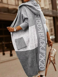 Person wearing a gray oversized sweater with 'Lookbook 2k20' text, holding a beige handbag.