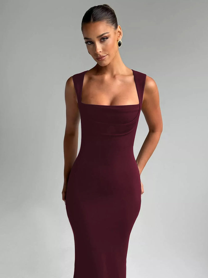Woman wearing a burgundy evening gown against a gray background