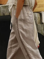 Person wearing light-colored pants with a blurred background