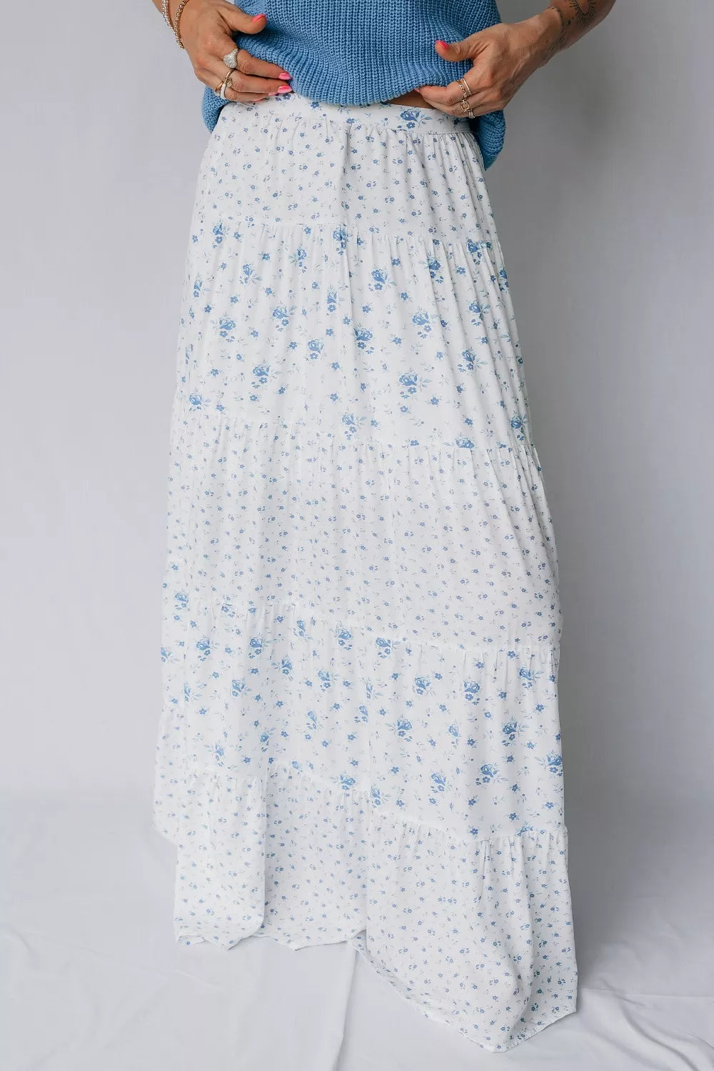 White floral skirt worn by a person on a plain background