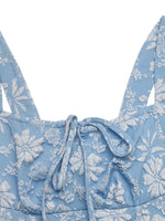 Blue floral patterned top with thin straps on a white background