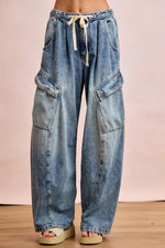 Wide-leg jeans with a drawstring waist on a plain background