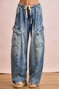 Wide-leg jeans with a drawstring waist on a plain background