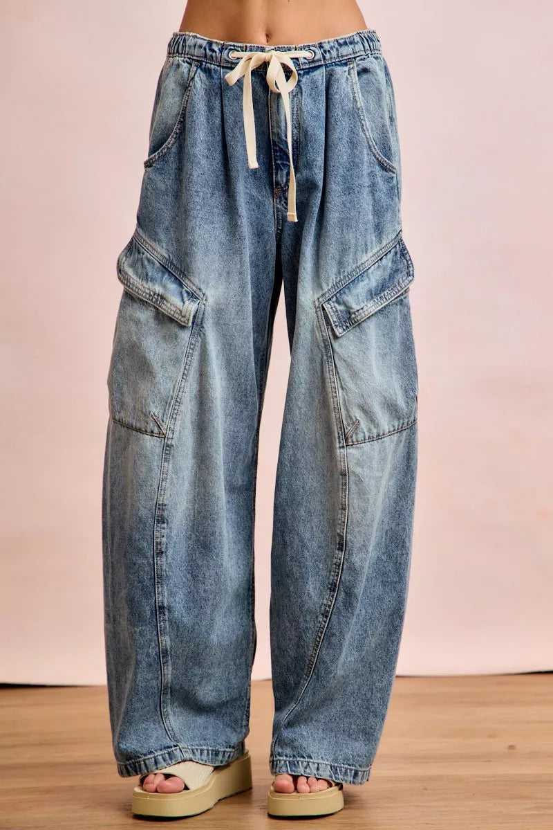 Wide-leg jeans with a drawstring waist on a plain background
