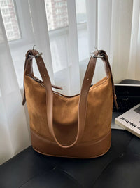 Brown leather handbag on a surface with a blurred background