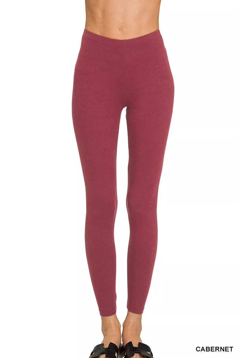 Maroon leggings worn by a person on a white background