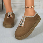 Brown slippers with decorative trim worn by a person on a light background