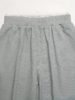 Gray sweatpants with lace trim on a white background