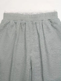 Gray sweatpants with lace trim on a white background