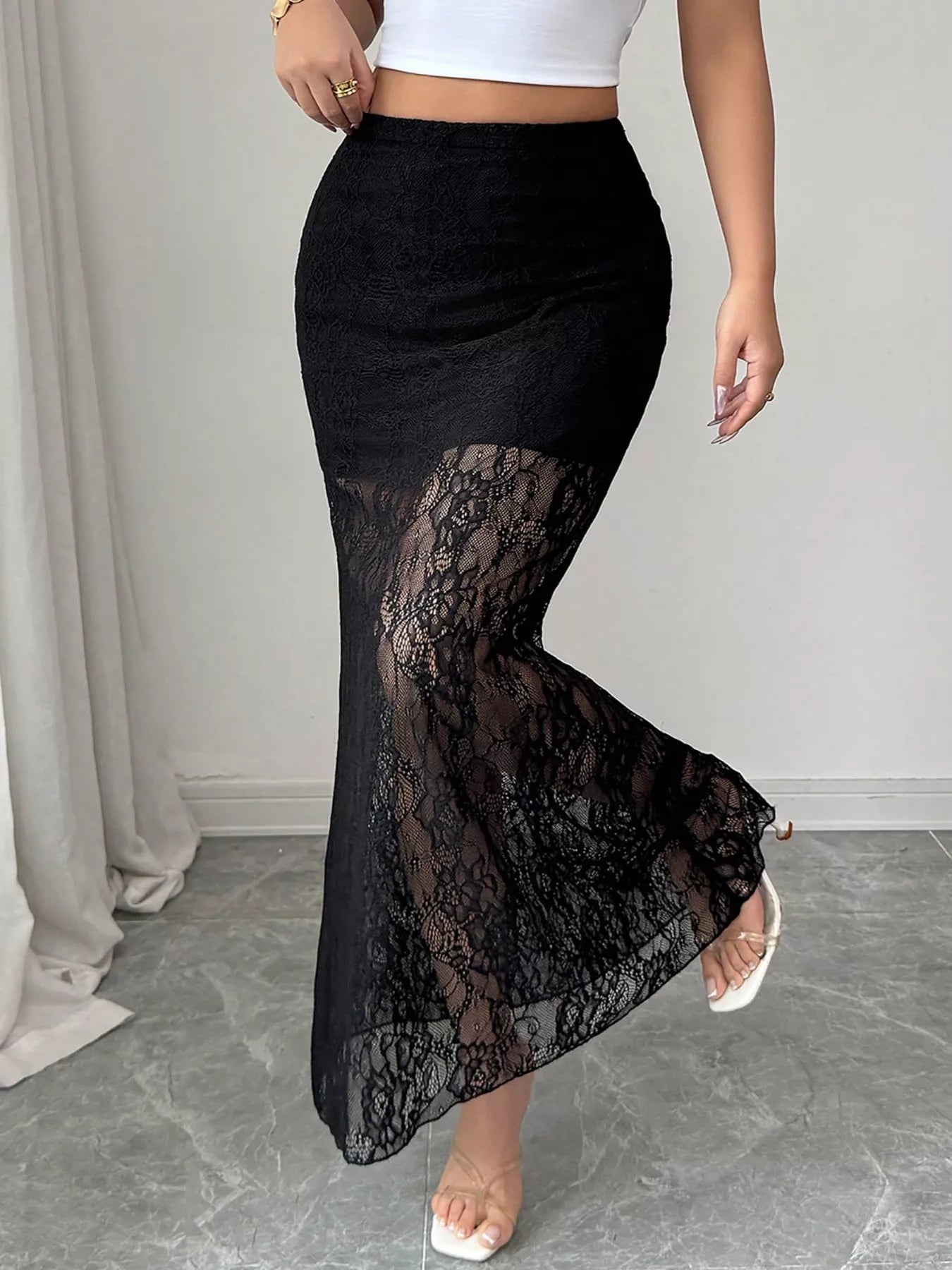 Black lace skirt worn by a person on a neutral background