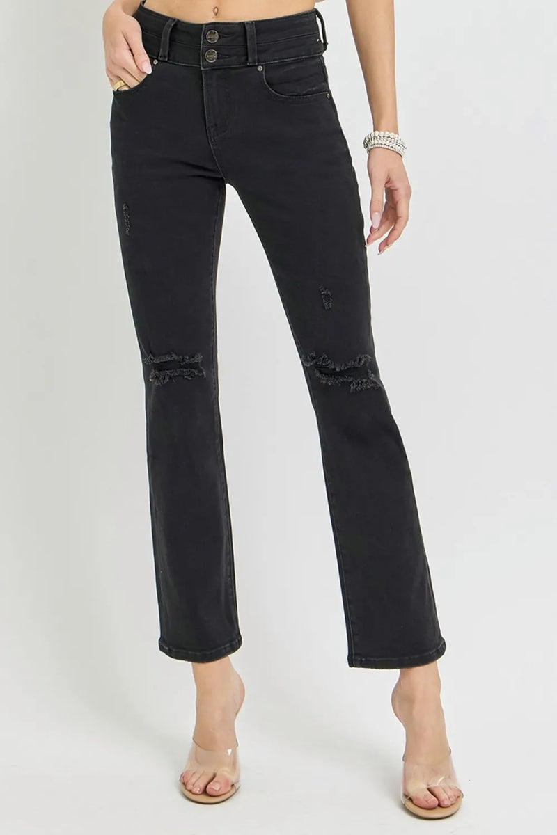 Black distressed jeans worn by a person on a white background